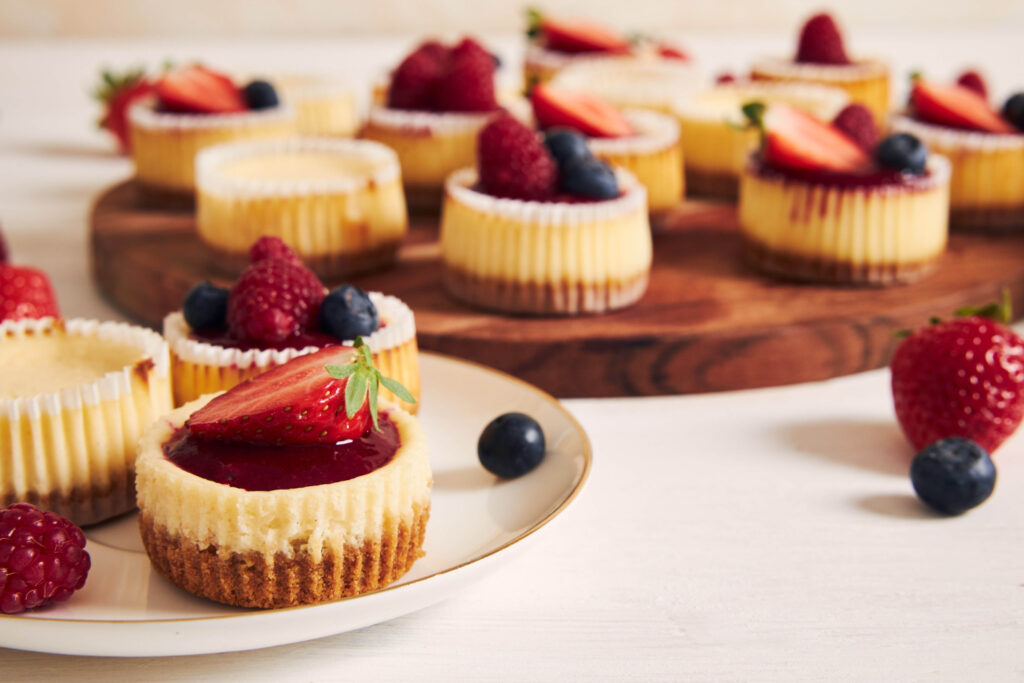 Assorted no-bake mini cheesecakes on display Preparing easy mini cheesecake recipes Variety of toppings for no-bake cheesecake bites Mini cheesecake variations served at a party